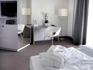 ein Hotelzimmer mit einem Bett mit einem Schreibtisch und Stühlen in der Unterkunft Hotel Schweizer Hof in Kassel + 27 Fotos
