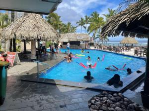 a group of people in a swimming pool at a resort at The Edgewater Resort & Spa in Rarotonga