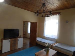 a living room with a couch and a tv and a window at Boros Vendégház I. in Kőszeg