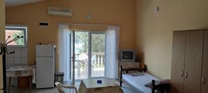 a room with a kitchen with a refrigerator and a table at Apartmani Jovanovic in Lustica