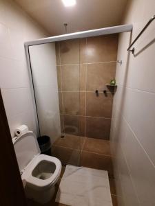 La petite salle de bains est pourvue d'une douche et de toilettes. dans l'établissement ONDAS PRAIA RESORT, à Porto Seguro