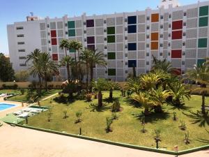an apartment building with a courtyard with palm trees at Atlantic Coast Apartment - Playa Del Inglés in Playa del Ingles