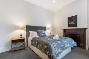 a bedroom with a bed and a fire place at Character on Stuart St in Dunedin
