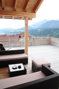 a deck with couches and a table on a roof at Penthouse Alpine Living direkt an der Skipiste by Schladmingurlaub in Haus im Ennstal