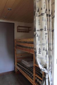 Ce lit superposé se trouve dans un dortoir doté d'un rideau. dans l'établissement Appartement T2 col de Merdassier au pied des pistes, à Manigod