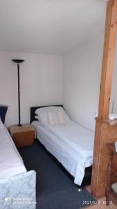 Un dormitorio con una cama y una lámpara. en Ravne Apartman, en Visoko