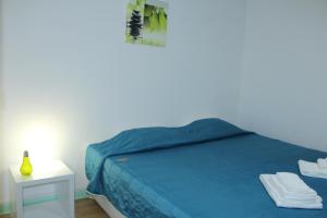 sypialnia z niebieskim łóżkiem i białym stołem w obiekcie Bella Italia Portas da Cidade w mieście Ponta Delgada
