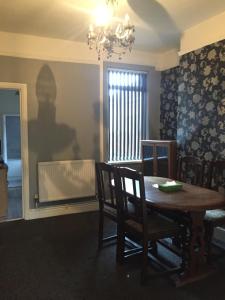 una sala da pranzo con tavolo, sedie e lampadario pendente di Private double room near City centre, Coventry a Coventry