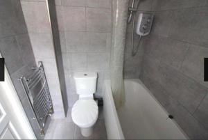 a bathroom with a toilet and a bath tub at Private double room near City centre, Coventry in Coventry