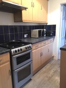 a kitchen with a stove and a microwave at Private double room near City centre, Coventry in Coventry