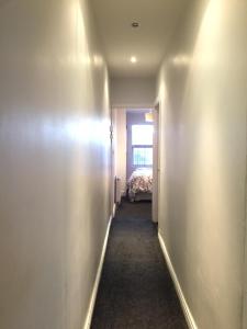 a hallway leading to a bedroom with a bed at Private double room near City centre, Coventry in Coventry