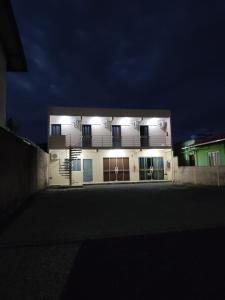 a white building with lights on the side of it at Suítes e PENHA-SC in Penha