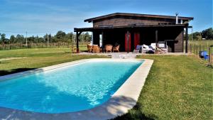 a swimming pool in front of a cabin at La Chacra Holandesa in Atlántida