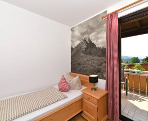 a bedroom with a bed and a window at Hotel AlpIn Bed & Breakfast in Fischen