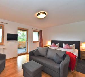 sala de estar con sofá y cama en Hotel AlpIn Bed & Breakfast, en Fischen