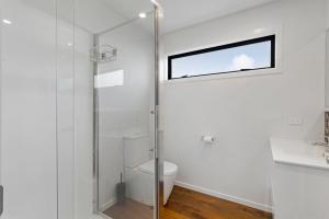 e bagno con servizi igienici e doccia in vetro. di Modern Charm a Dunedin