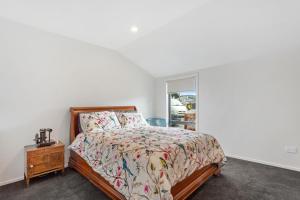 una camera con letto, comodino e finestra di Modern Charm a Dunedin