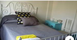 a bed with a white headboard and a blue night stand at Apartamento Luminoso y cómodo in Seville