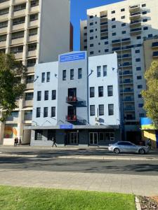 a white building with a car parked in front of it at Akara Perth in Perth