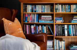 a book shelf filled with books with a chair in front at Queenstown Country Lodge in Queenstown