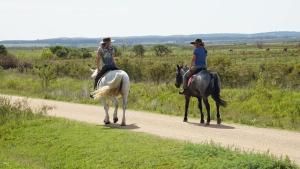two women riding horses on a dirt road at La Chacra Holandesa in Atlántida
