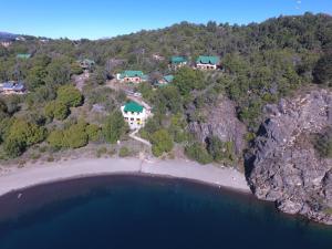 an aerial view of a house on a hill next to the ocean at Cabañas Bahia Radal in Villa Pehuenia