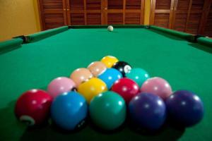 a group of billiard balls on a green pool table at Ilha Flat Hotel Ap 2202 in Ilhabela