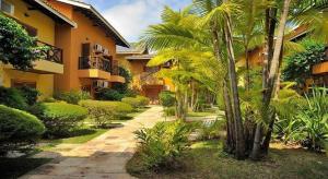 a courtyard with palm trees and a building at Ilha Flat Hotel Ap 2202 in Ilhabela