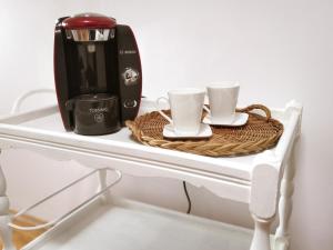 eine Kaffeemaschine und zwei Tassen auf dem Tisch in der Unterkunft Maison de charme spacieuse, terrasse et vue sur la place in Monflanquin