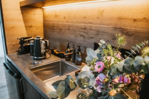 a kitchen counter with a sink and some plants at Cross Hill Glamping in Lake Hāwea