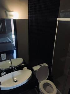 a bathroom with a white toilet and a sink at Suíte 101- Espaço Praia Aptos in Angra dos Reis