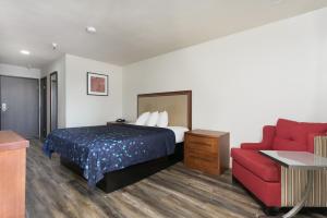a hotel room with a bed and a red couch at Waterloo Inn in Stockton