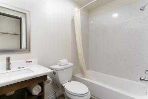 a bathroom with a toilet and a sink and a tub at Waterloo Inn in Stockton