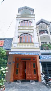 a tall white building with a clock tower at THANH TÙNG HOTEL in Quy Nhon