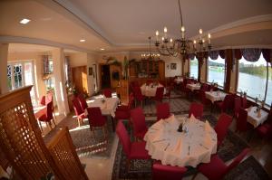 a dining room with tables and red chairs at Fischwirtshaus Landmotel Die Donaurast in Persenbeug-Gottsdorf