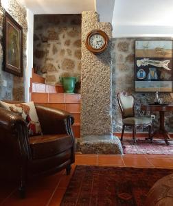 un soggiorno con divano e orologio sul muro di Anibals Boutique Lodging - Serra da Estrela a Gouveia