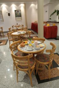 une salle à manger avec des tables et des chaises avec de la nourriture dans l'établissement Gran Hotel Ailen, à Buenos Aires