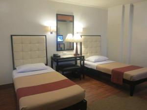 سرير أو أسرّة في غرفة في Hotel Alejandro Tacloban