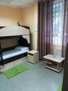 a bedroom with a bunk bed and a table at Dachny Hostel на метро "Заельцовская" in Novosibirsk