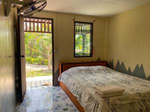 a bedroom with a bed and a window at Tribal Pai in Pai