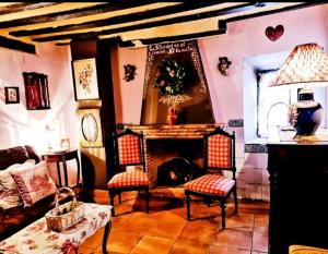 sala de estar con chimenea, 2 sillas y mesa en Room in Lodge - Romantic getaway to Cuenca The fifth en Valeria