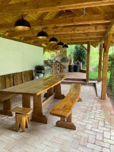 een houten tafel en banken op een patio bij Bell House in Bükkzsérc