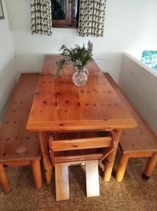 einen Holztisch mit einer Blumenvase darauf in der Unterkunft Villa with garden and terrace for 8 pax in Capoliveri