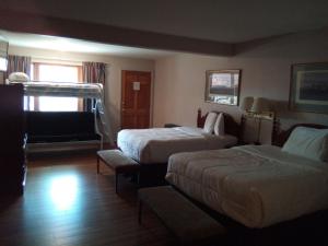 a hotel room with two beds and a couch at Stay Saratoga in Saratoga Springs