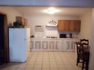 a kitchen with white cabinets and a white refrigerator at Stay Saratoga in Saratoga Springs