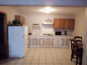 uma cozinha com armários brancos e um frigorífico branco em Stay Saratoga em Saratoga Springs