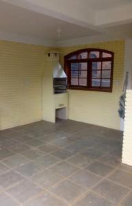 an empty room with a kitchen with a window at O Silêncio que Canta in Águas de Lindóia
