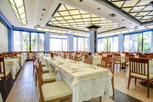 a dining room with tables and chairs and windows at Hotel Rosalba - Valentini Family Village in Bellaria-Igea Marina