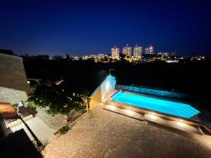 a swimming pool with lights on a rooftop at night at Apartments Nona in Pula