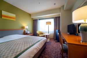 a hotel room with a bed and a desk and a television at JR Hotel Clement Tokushima in Tokushima +37 photos